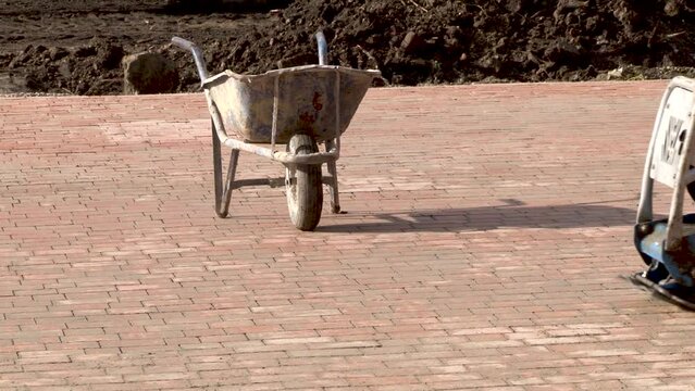 Machine for compaction, vibrating plates on paving stones. The concept of laying paving slabs and paving stones.
Workers using a vibro-compacting plate to compact self-locking blocks in their laying b