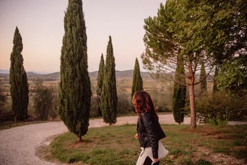 Fotobehang woman walking in tuscan landscape © Sina