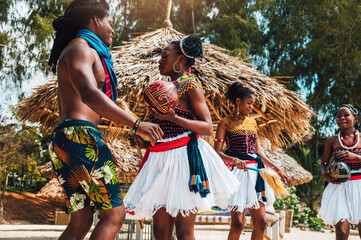 Kenyan people dance on the beach with typical local clothes