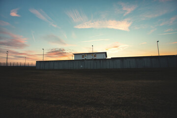 A prison with high concrete walls and barbed wire.
