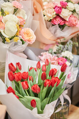 Obraz na płótnie Canvas Flower shop concept. Different varieties fresh spring flowers in refrigerator room for flowers. Bouquets on shelf, florist business