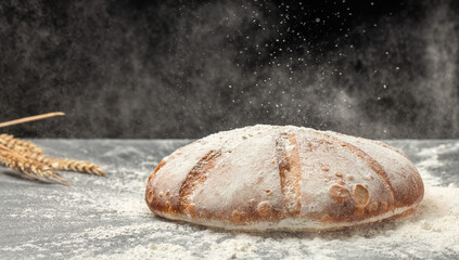 Homemade sourdough bread with powder in a freeze motion of a cloud of powder midair. Culinary,...