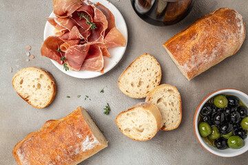 Delicious appetiser Italian prosciutto and Spanish Iberian ham snack bread ciabatta and olives....
