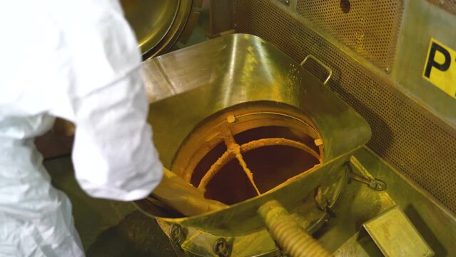 Someone at factory folding empty bag after pouring out all raw paint