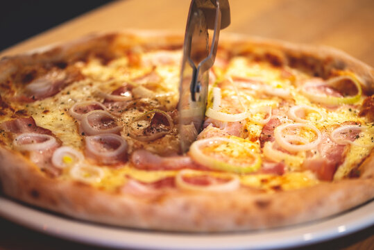 Photo of baked pizza. Pizza on a white plate. Pizza baked in the oven. Pizza with meat. Pizza with sauces in bowls.