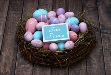 Étiquette avec le texte Joyeuses Pâques sur un nid avec des oeufs de Pâques dans des tons pastel...