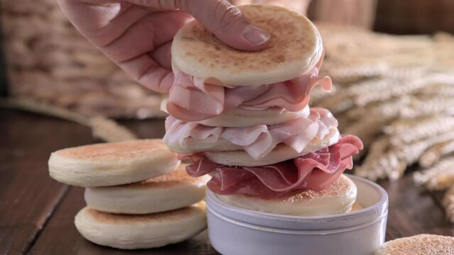 tigelle or crescentine homemade, con prosciutto, salame, stracciatella liquida. Italian food typical of the area of Modena, Emilia-Romagna. Thin round breads stuffed with prosciutto. 4k footage