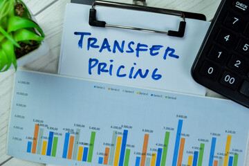 Concept of Transfer Pricing write on paperwork isolated on Wooden Table.