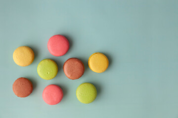 Obraz premium Multi color macaroons on turquoise background top view flat lay