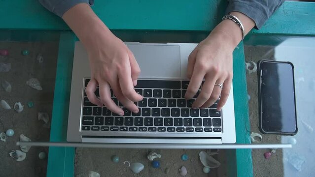 A large plan of women's palms that fluently enter text on a laptop