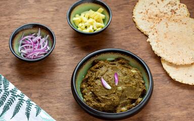 Sarson ka saag traditional Indian dish with corn bread (Makki di roti) with shallots and ginger. Homemade food meal.