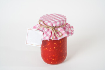 Top view of canned homemade chili tomato sauce jar with empty label isolated on white background.