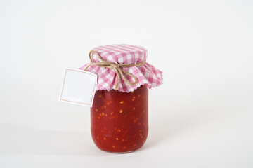 Canned homemade chili tomato sauce jar with empty label isolated on white background.