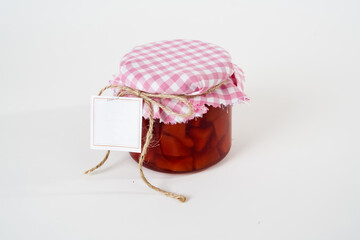 Fototapeta na wymiar Jar of homemade quince jam with empty label isolated on white background.
