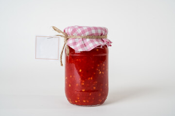 Canned homemade chili tomato sauce jar with empty label isolated on white background.
