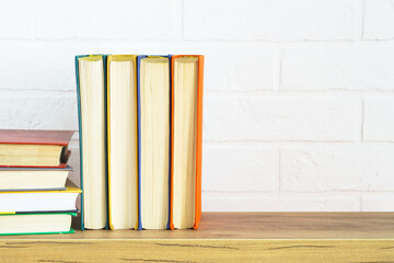 Fototapeta na wymiar Bookshelf with colored books and on the white wall background.