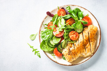 Healthy food plate. Green salad with chicken fillet on white. Top view with copy space.