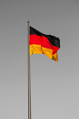 German flag on a flagpole against the blue sky