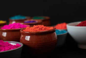 Indian festival Holi, Multi colors wooden bowl on dark background