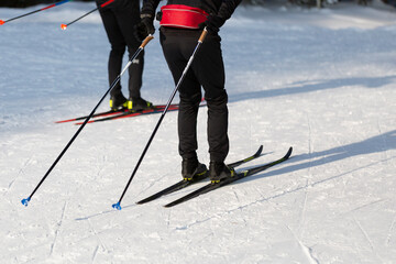 A man goes cross-country skiing in winter through the forest on a special track.
