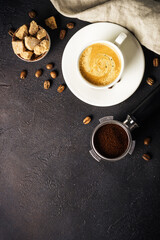 Coffee cup and coffee beans at dark table . Top view image with copy space.