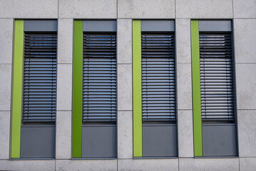 green and blue windows with shutters, facade in a modern city