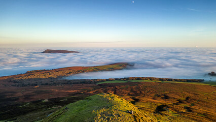 Aerial view of hillsides above a temperature inversion and sea of fog at sunset