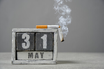 May 31, wooden calendar and smoking cigarette gray background.Concept for World No Tobacco Day.