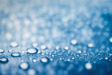 Droplet is perched delicately on a smooth surface with a background of sparkling bokeh lights.
