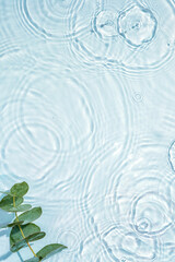 Naklejka na ściany i meble Blue water texture, surface with rings and ripples. Green leaves on water surface. Spa concept background. Flat lay, copy space.