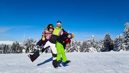 Dad with children on skiing in the mountains looking into the camera