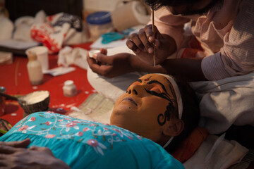 Kathakali artist applying makeup