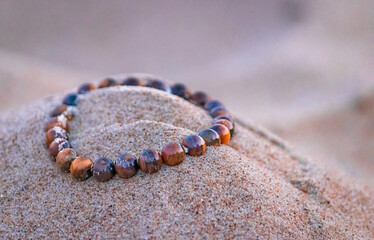 tiger eye crystal on beach sand in Bournemouth, England