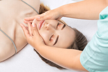 The masseur makes a face, neck and head massage in the spa salon.Cosmetology treatment