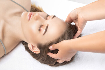 The masseur makes a face, neck and head massage in the spa salon.Cosmetology treatment