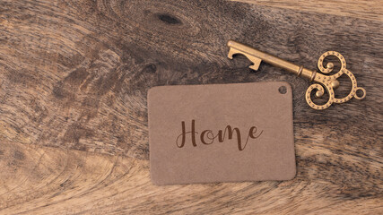 Key with Home tag, isolated on wooden background