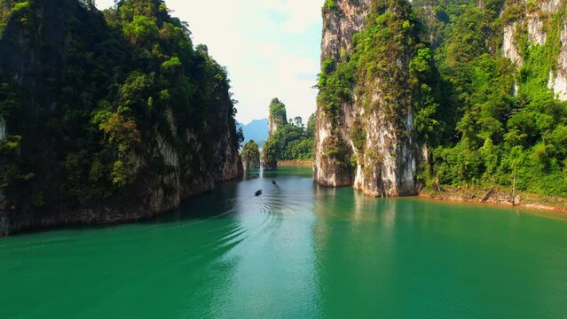 Experience the untouched beauty of "Khao Sam Kloe" from aerial perspective. Admire the lush green forests, lake, towering mountains. (Khao Sok National Park, Surat Thani Province, Thailand). 4K Drone
