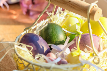 Easter Eggs in a rustic basket on a wooden windowsill bathed in sunlight. Above view. Easter decor