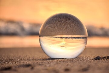 Abstract holiday seaside idea. Sea landscape held in a glass ball with a blurred background.  Photo in shallow depth of field.