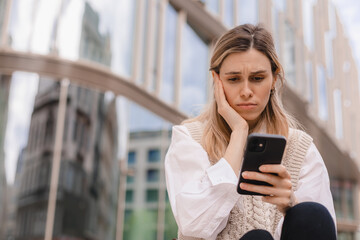 Sad being victim of cyber bullying online, anxious women checks the phone, reads a message on the...