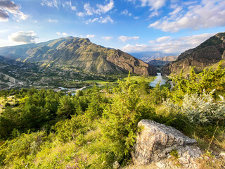 Fototapeta na wymiar Beautiful view of the valley in the mountains with a river on a sunny summer day. Dagestan