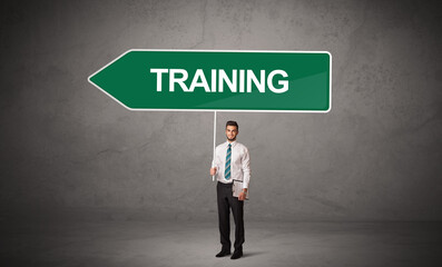 Young business person in casual holding road sign