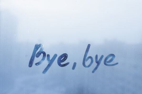lettering Bye, bye on foggy glass on blue window
