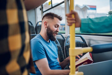 Fototapeta na wymiar Man is reading a book while riding in a bus