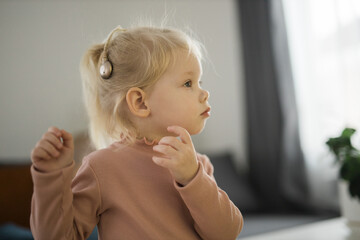Cochlear implant system. Installation cochlear implant on child girl ear for restores hearing. Kid...