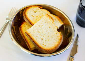 Pieces of fresh bread served on table. Baked pastries on plate.