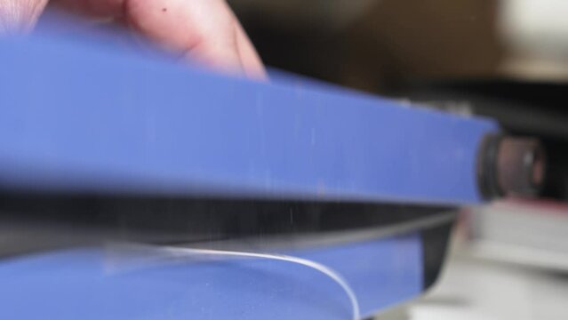 narrow depth of field. Men's hands cut photos on the cutter.