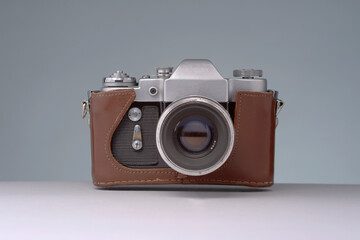 A vintage steel 35mm camera with leather case on isolated background