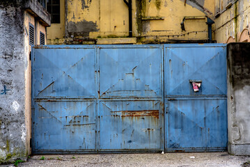 Old blue gate of an abandoned factory.