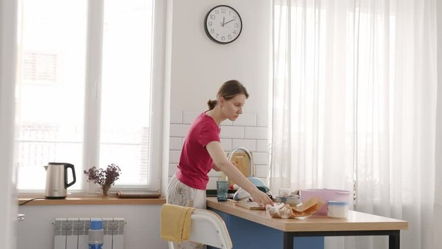 A girl washes dishes in the kitchen
